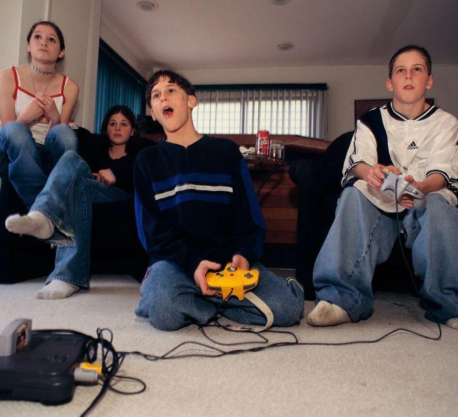 Gyerekek régi videójátékon játszanak a TV előtt